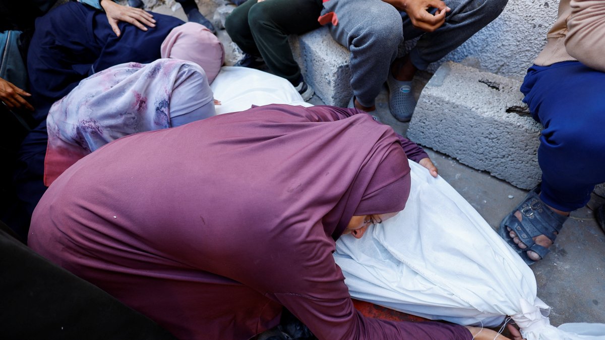 The mother of Palestinian Mohammed Al-Motawak, who was killed by Israeli fire while trying to receive aid on Sunday, mourns over his body during his funeral at Al-Shifa Hospital, Gaza City, Palestine, Aug. 4, 2025. (Reuters Photo)