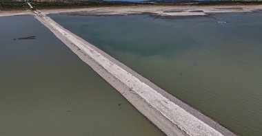 A section of the old Izmir-Çeşme highway emerges as water levels drop at the Alaçatı Kutlu Aktaş Dam, captured by drone, Izmir, Türkiye, Aug. 3, 2025.