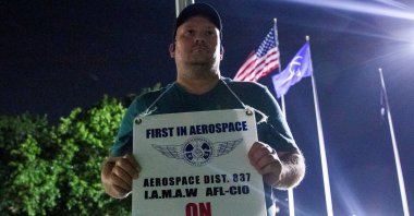 A worker holds a picket sign, as people protest during a walkout by members of the International Association of Machinists and Aerospace Workers (IAM) over contract negotiations, outside a Boeing facility, Berkeley, Missouri, U.S., Aug. 4, 2025. (Reuters Photo)