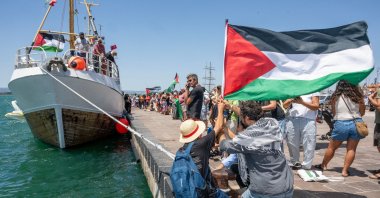 People gather with Palestinian flags around the Freedom Flotilla ship &quot;Handala&quot; ahead of the boat&#039;s departure for Gaza at a port in Syracuse, Sicily, southern Italy, July 13, 2025. (AFP Photo)