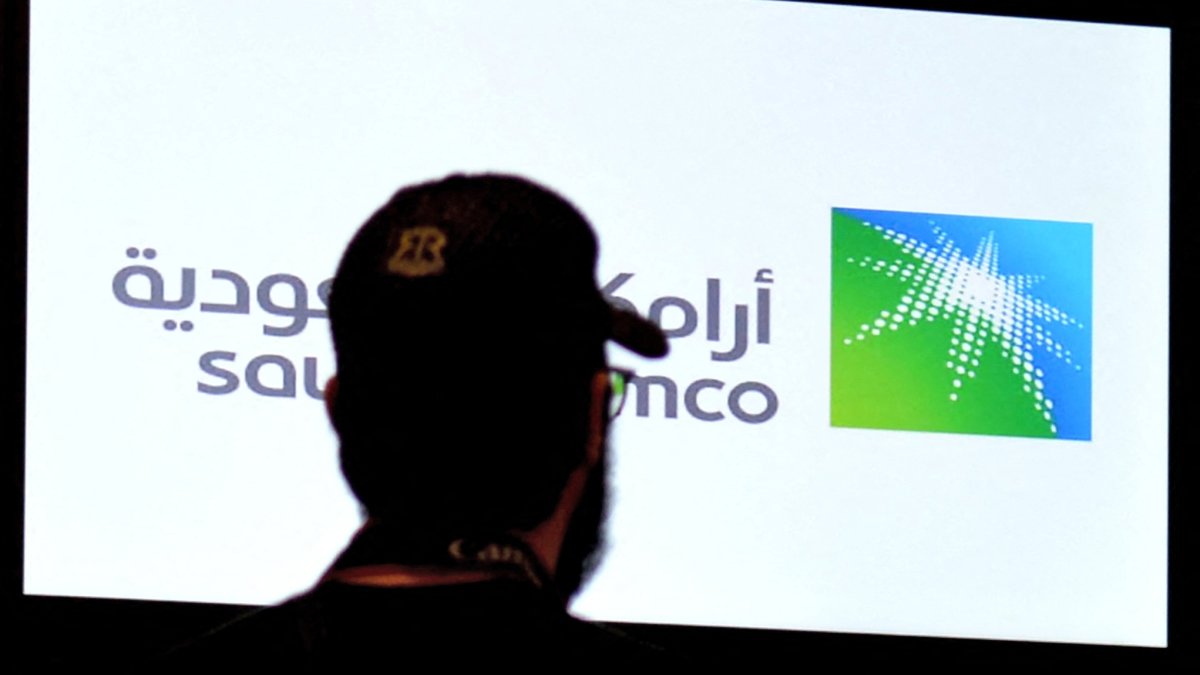 A man looks at the exchange board at the Saudi Stock Exchange (Tadawul) bourse in Riyadh, displaying Aramco shares on the second day of their trading, Saudi Arabia, Dec. 12, 2019. (AFP Photo)