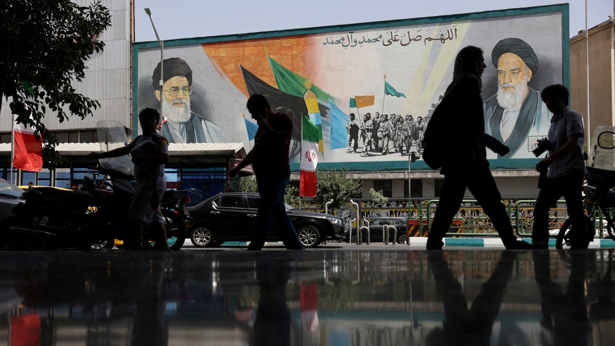 People walk next to a mural with a picture of Iran&#039;s Supreme Leader, Ayatollah Ali Khamenei, on a street, early hours of ceasefire, in Tehran, Iran, June 24, 2025. (Reuters File Photo)