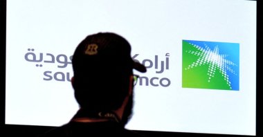 A man looks at the exchange board at the Saudi Stock Exchange (Tadawul) bourse in Riyadh, displaying Aramco shares on the second day of their trading, Saudi Arabia, Dec. 12, 2019. (AFP Photo)