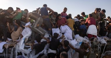 Internally displaced Palestinians climb aid trucks to get food near a food distribution point in the Morag corridor, south of Khan Younis, Gaza Strip, Palestine, Aug. 4, 2025. (EPA Photo)