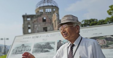 Kunihio Iida, atomic bomb survivor and a volunteer guide at the iconic exhibition hall best known as the Atomic Bomb Dome, speaks in English to foreign visitors, Hiroshima, Japan, July 9, 2025. (AP Photo)