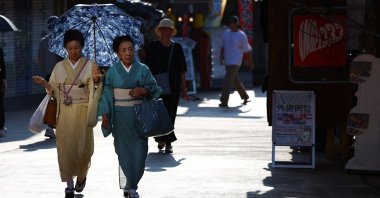 Women in traditional kimonos walk under a parasol as the Japanese government issued a heatstroke alert in Tokyo and other prefectures due to a heat wave, Tokyo, Japan, Aug. 5, 2025. (Reuters Photo)