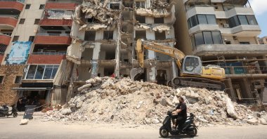A man rides on a motorbike past a building damaged during Israeli attacks in the southern city of Tyre, Lebanon July 3, 2025. (Reuters Photo)