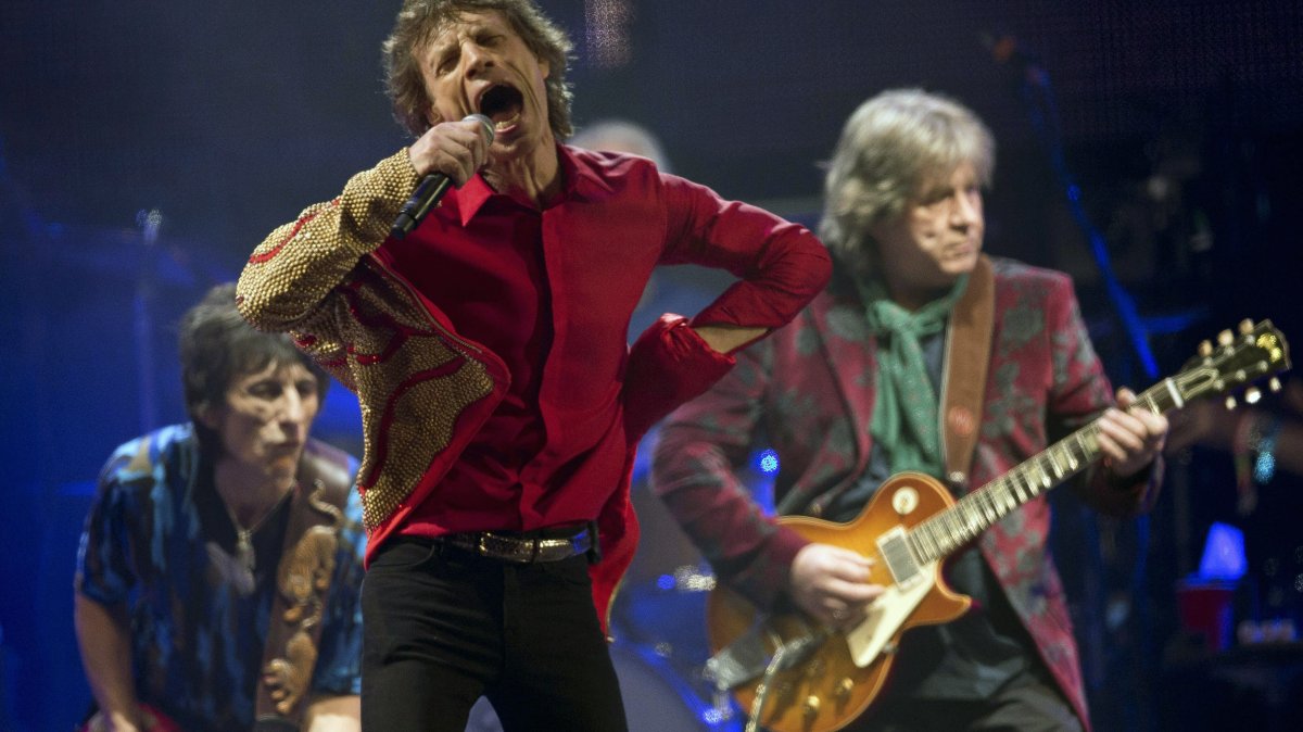 Mick Jagger (C), Ronnie Wood (L) and Mick Taylor of British rock band The Rolling Stones perform on the Pyramid main stage at Glastonbury, England, June 29, 2013. (AP Photo)