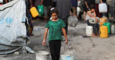 A Palestinian girl carries buckets of water amid shortages, Gaza City, Palestine, Aug. 6, 2025. (Reuters Photo)