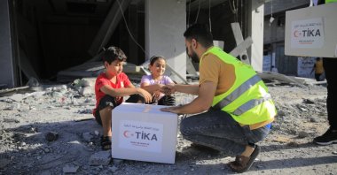 A volunteer is seen delivering humanitarian aid provided by the Turkish Cooperation and Coordination Agency (TIKA) in an undisclosed location on Jan. 6, 2024. (AA File Photo)