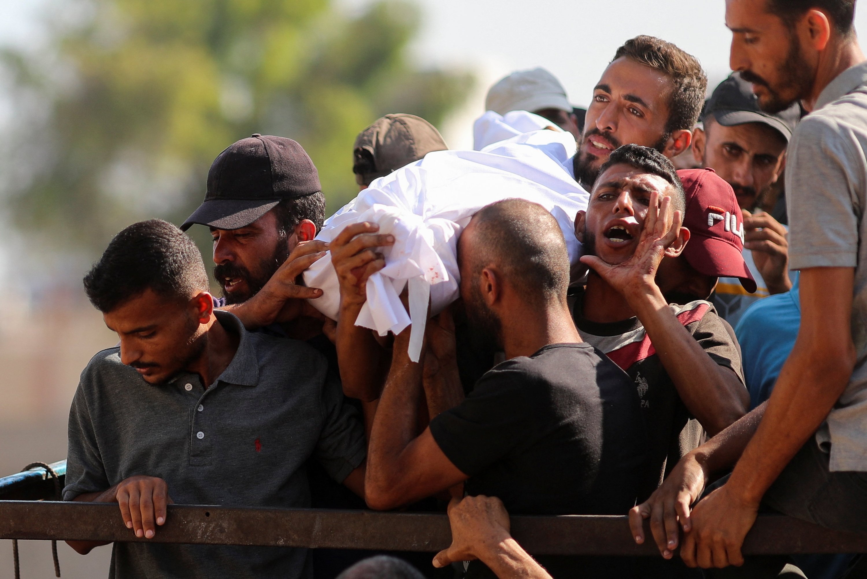 People mourn as they carry the body of a Palestinian, who was killed by Israeli fire while trying to receive aid on Tuesday, according to medics, during a funeral at Al-Shifa Hospital, Gaza City, Palestine, Aug. 6, 2025. (Reuters Photo)