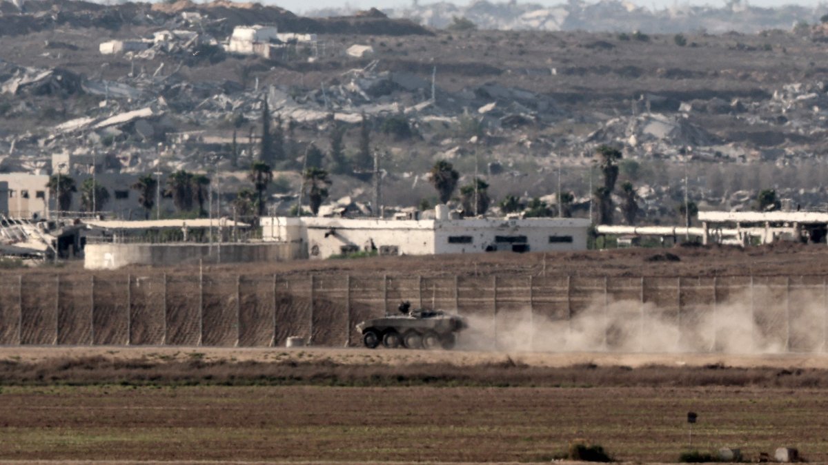This picture, taken from a position on the Israeli border with the Gaza Strip, shows an Israeli armored vehicle near the separation fence and the destruction in the besieged Palestinian territory, Aug. 7, 2025. (AFP Photo)