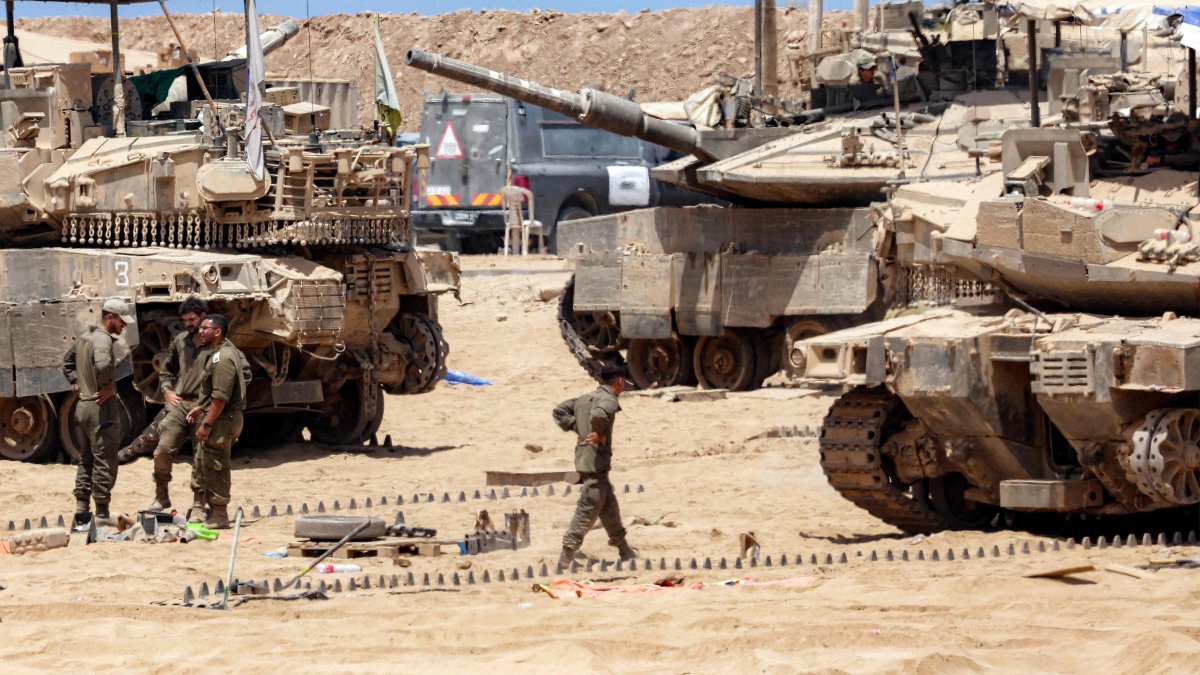 Israeli army soldiers perform maintenance tasks near main battle tanks positioned near the border, Gaza Strip, Palestine, Aug. 5, 2025. (AFP Photo)