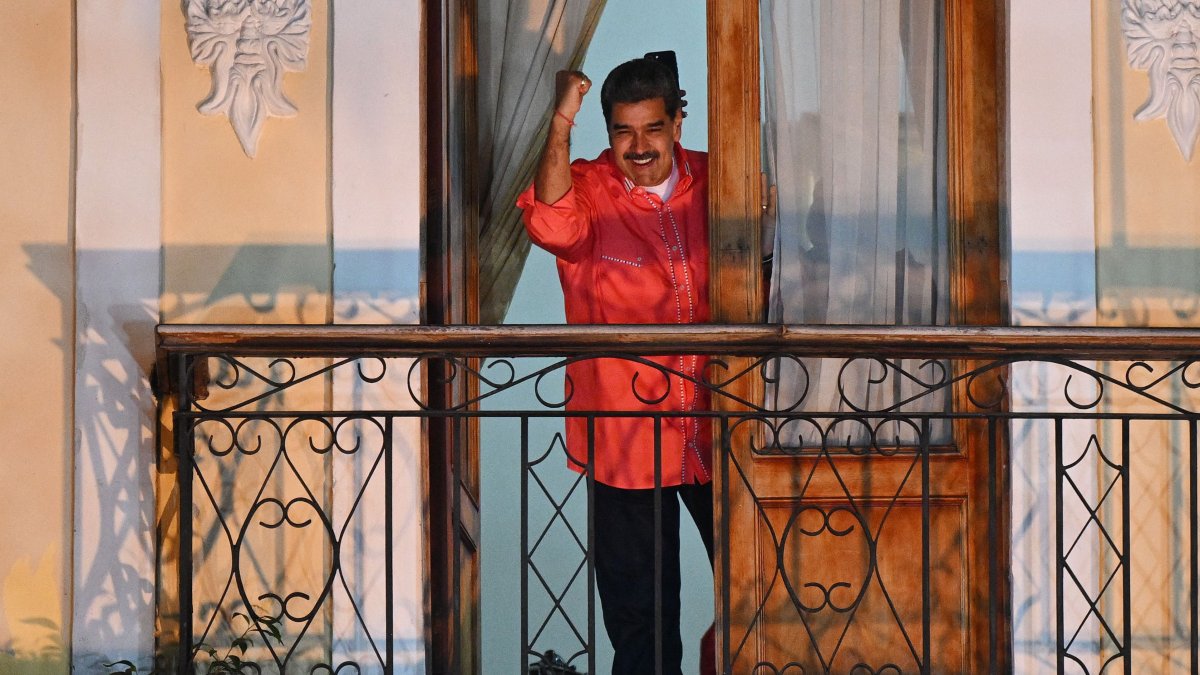 Venezuelan President Nicolas Maduro waves to supporters from a balcony as he celebrates the results of the parliamentary and regional elections at the Bolivar square in Caracas, May 25, 2025. (AFP File Photo)