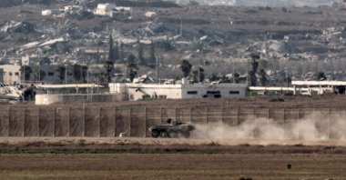 This picture, taken from a position on the Israeli border with the Gaza Strip, shows an Israeli armored vehicle near the separation fence and the destruction in the besieged Palestinian territory, Aug. 7, 2025. (AFP Photo)