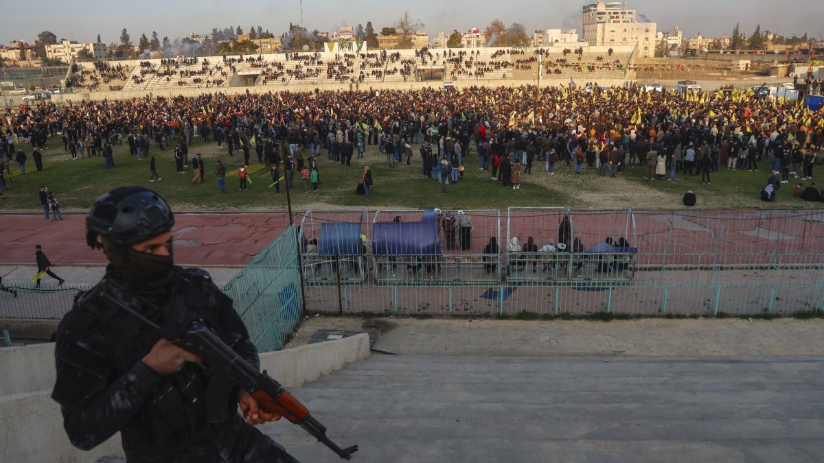 A YPG terrorist watches as hundreds attend a gathering to listen to a statement from the jailed leader of the PKK terrorist group, Qamishli, Syria, Feb. 27, 2025. (AP Photo)