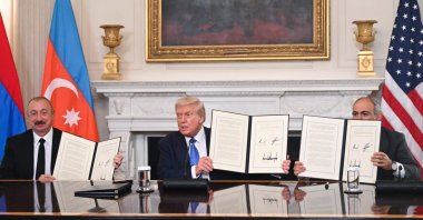 US President Donald Trump (C), Azerbaijani President Ilham Aliyev (L) and Armenian Prime Minister Nikol Pashinyan display the agreement they signed in Washington D.C., U.S., Aug. 8, 2025. (AFP Photo)