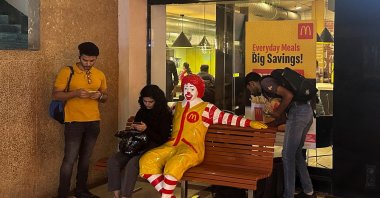 A person sits outside a McDonald&#039;s restaurant in Mumbai, India, Feb. 26, 2024. (Reuters Photo)