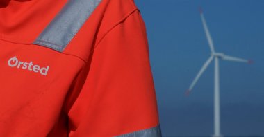 The logo for Orsted can be seen on the jacket worn by an employee as he talks to journalists during a visit to the offshore wind farm near Nysted, Denmark, Sept. 4, 2023. (Reuters Photo)
