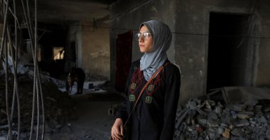 Maha Ali looks at the destruction of the Islamic University of Gaza, where she now shelters, Gaza City, Palestine, June 1, 2025. (Reuters Photo)