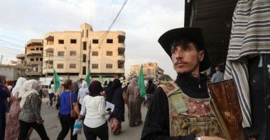 A member of the YPG stands guard as Syrian Kurds attend a protest in solidarity with people in Suwayda, Qamishli, Syria, July 17, 2025. (REUTERS Photo)