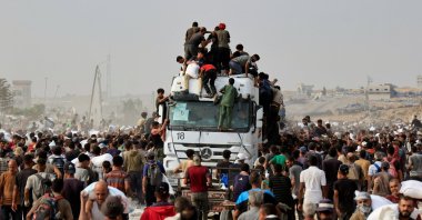 Palestinians scramble to collect aid supplies from trucks in Khan Younis, southern Gaza Strip, Aug. 12, 2025. (Reuters Photo)