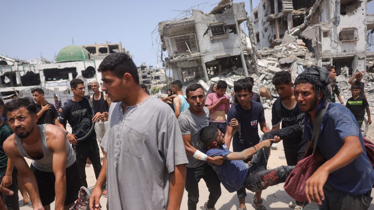 Palestinians carry casualties of Israeli strikes near an aid distribution center in the Saftawi neighborhood, west of Jabalia in the northern Gaza Strip, Aug. 13, 2025. (AFP Photo)