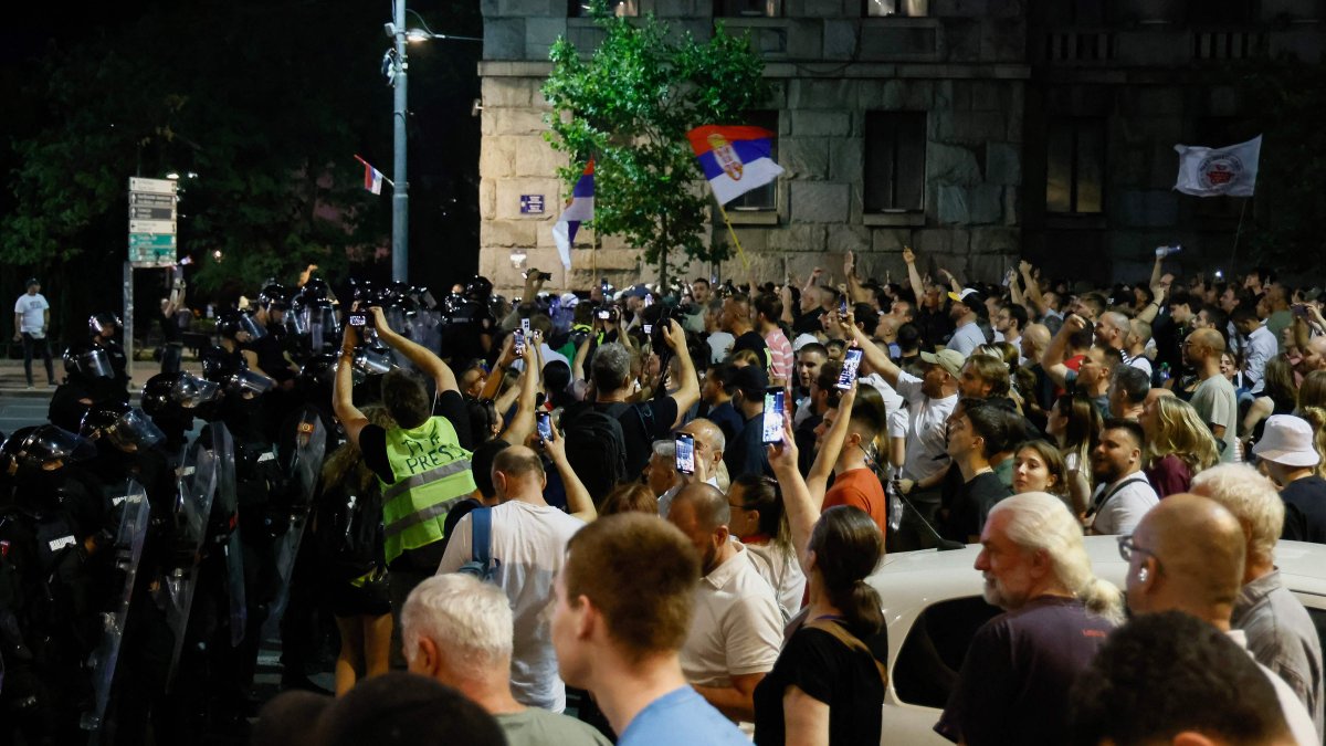 Serbian riot police stand in front of anti-government protesters preventing them from approaching ruling party supporters in Belgrade, Aug. 13, 2025. (AFP Photo)