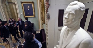 A bust of former President Richard Nixon looks is on display in the hallway outside the Senate chamber as Senator Ron Johnson (center back) talks to reporters, prior to the start of the impeachment trial of President Donald Trump at the U.S. Capitol, Washington, U.S., Jan 31, 2020. (AP Photo)