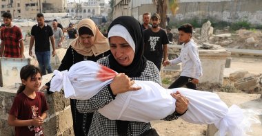 Palestinian woman Soha Tafesh carries the body of her granddaughter Sarah Abu Daf, who was killed in an early morning Israeli strike on a house, according to medics, at a cemetery, Gaza City, Palestine, Aug. 13, 2025. (Reuters Photo)