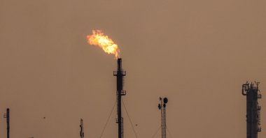 A bird flies past burning gas flares at the Dora (Daura) Oil Refinery Complex, Baghdad, Iraq, July 15, 2025. (AFP Photo)