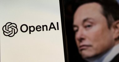 This photo illustration shows the OpenAI logo displayed on a smartphone screen with Elon Musk&#039;s account photo profile in the background, Bandung, West Java, Indonesia, Feb. 12, 2025. (Shutterstock Photo)