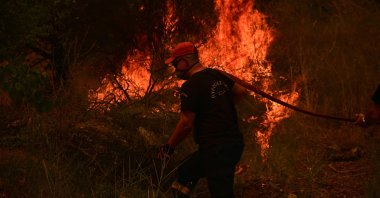 A firefighter works to extinguish a wildfire, Patras, Greece, Aug. 13, 2025. (AFP Photo)