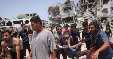Palestinians carry casualties of Israeli strikes near an aid distribution center in the Saftawi neighborhood, west of Jabalia in the northern Gaza Strip, Aug. 13, 2025. (AFP Photo)
