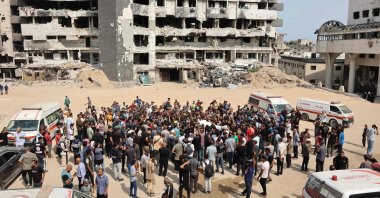 Mourners carry the bodies of Palestinians, including journalists and a medic, killed in an overnight Israeli strike, ahead of a group funeral outside the Al-Shifa Hospital destroyed by Israel in Gaza City, Aug. 11, 2025. (AFP Photo)