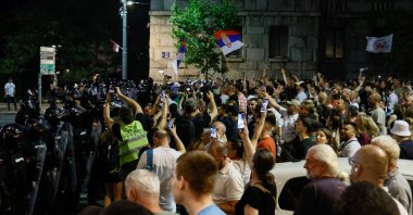 Serbian riot police stand in front of anti-government protesters preventing them from approaching ruling party supporters in Belgrade, Aug. 13, 2025. (AFP Photo)