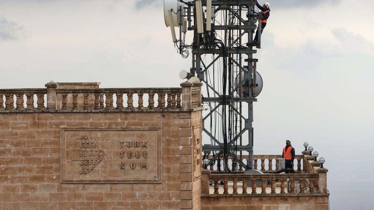 Türk Telekom technicians work on a telecommunications tower atop a historic building, Mardin, southeastern Türkiye, Dec. 29, 2024. (DHA Photo)