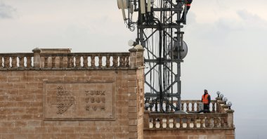 Türk Telekom technicians work on a telecommunications tower atop a historic building, Mardin, southeastern Türkiye, Dec. 29, 2024. (DHA Photo)