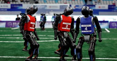Booster Robotics T1 humanoid robots take part in a 5-on-5 football group match on a football pitch at the inaugural World Humanoid Robot Games, at the National Speed Skating Oval, Beijing, China, Aug. 15, 2025. (Reuters Photo)