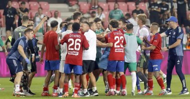 A heated confrontation unfolds on the pitch as Maccabi Haifa and Rakow Czestochowa players clash during their Europa Conference League match, with coaches and staff stepping in to de-escalate the tension, while a provocative banner looms in the stands reading "MURDERERS SINCE 1939," Debrecen, Hungary, Aug. 14, 2025. (Reuters Photo)