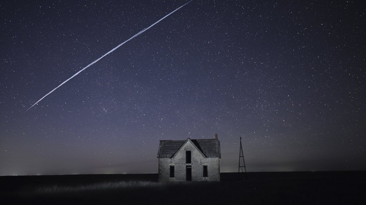 In this long exposure photo, a string of SpaceX StarLink satellites passes over an old stone house near Florence, Kansas, U.S., May 6, 2021. (AP Photo)