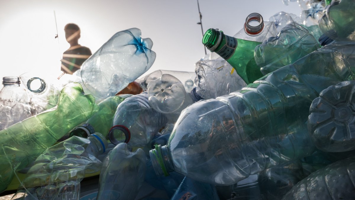 A boy walks past an artwork designed to raise awareness of plastic pollution at the United Nations office, Geneva, Switzerland, Aug. 15, 2025. (AFP Photo)