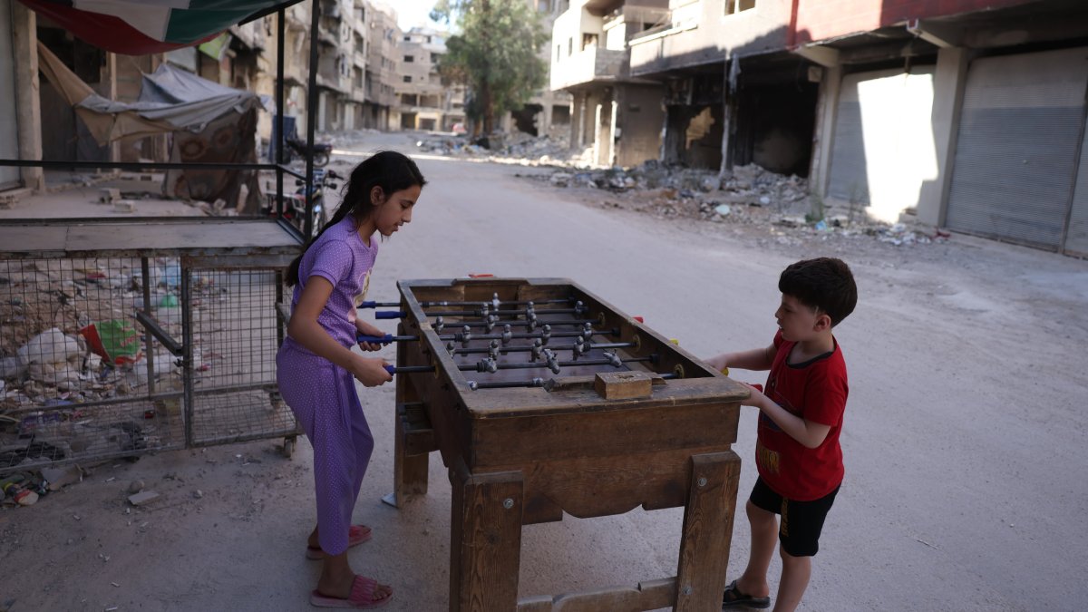 Two children play amid destroyed houses, ruined mosques and empty streets near Damascus, Syria, Aug. 16, 2025. (AA)