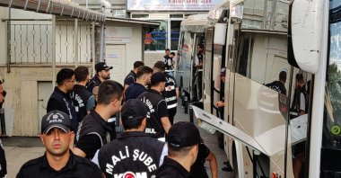Police officers guard buses carrying suspects accused of corruption at Istanbul municipality, in Istanbul, Türkiye, Aug. 1, 2025. (DHA Photo) 