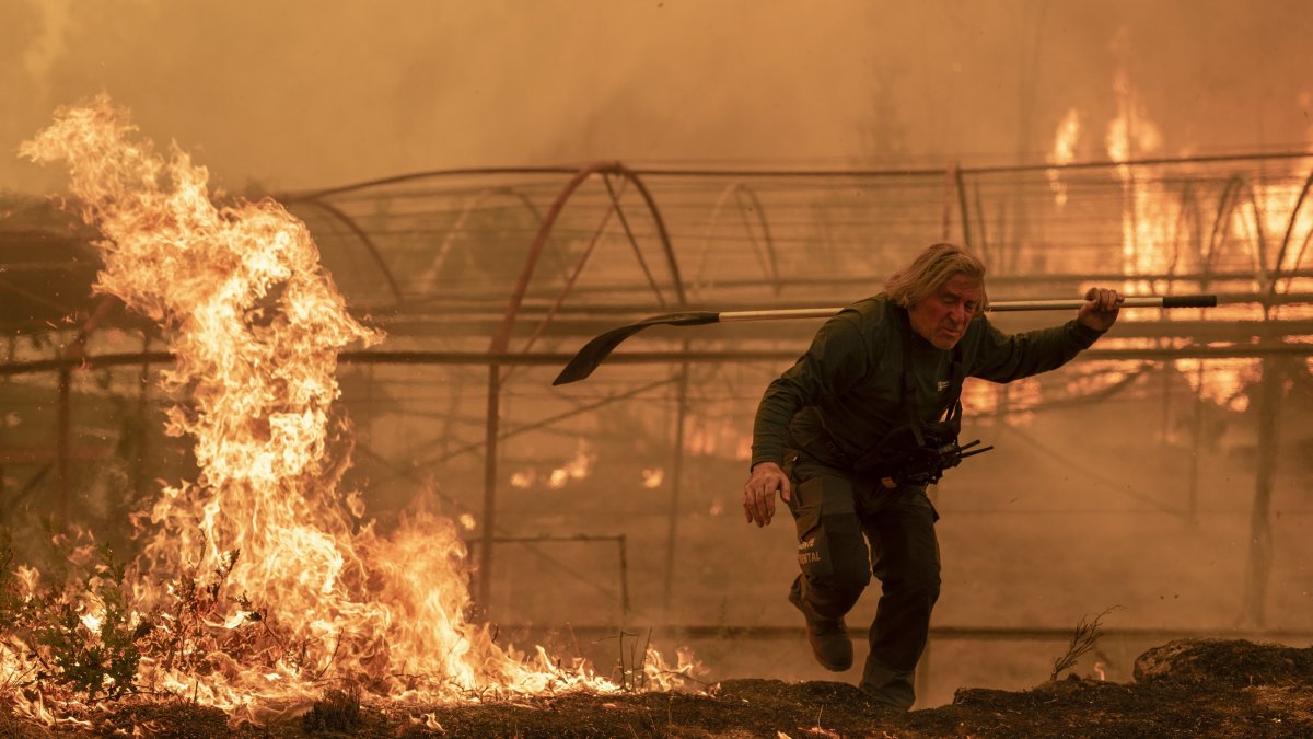 A forest guard works to extinguish a forest fire in Carballeda de Avia, Ourense, Galicia, north-western Spain, Aug. 17, 2025. (EPA Photo)