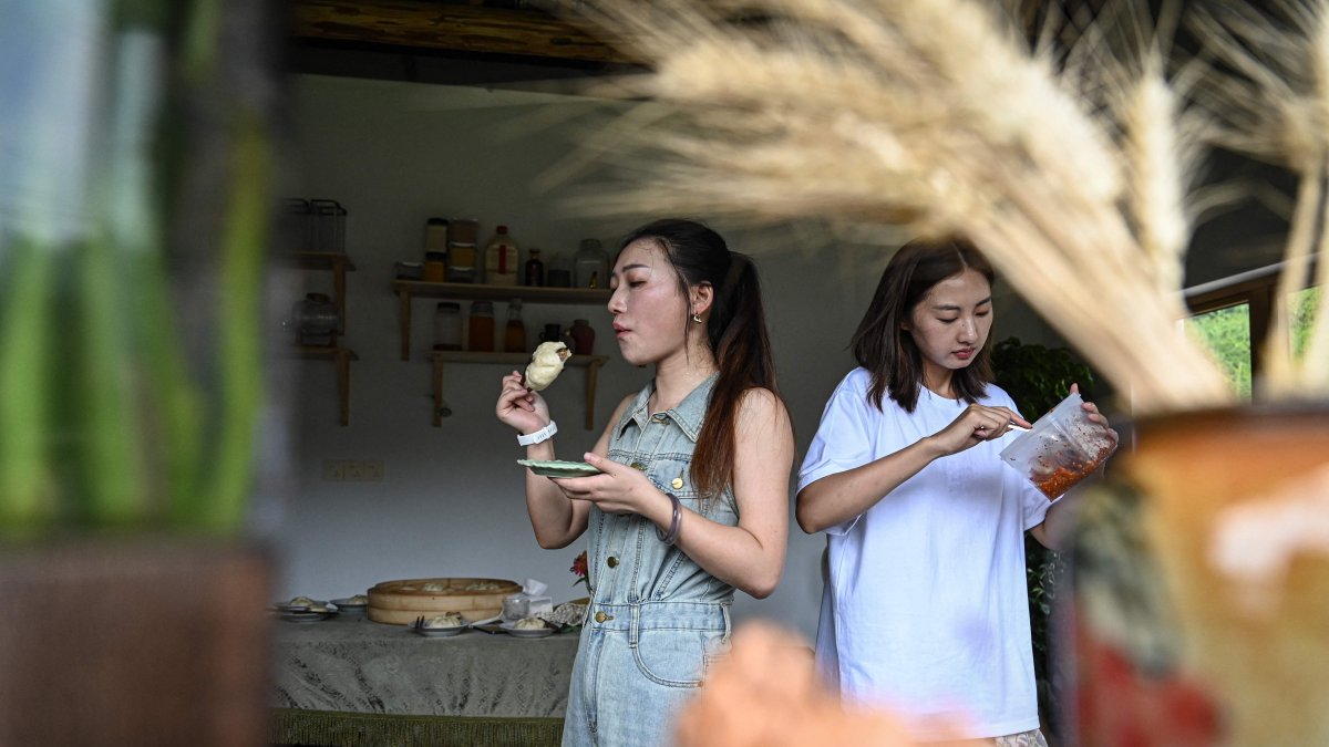 Chen Yani (R), also known as &quot;Keke,&quot; eating lunch with friends and guests in a female co-living space called &quot;Keke’s Imaginative Space,&quot; Hangzhou, Zhejiang Province, China, July 14, 2025. (AFP Photo)