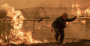 A forest guard works to extinguish a forest fire in Carballeda de Avia, Ourense, Galicia, north-western Spain, Aug. 17, 2025. (EPA Photo)