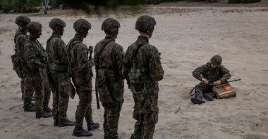 Volunteers listen to the military instructor during a military training that is part of the "Vacation with the Army" project, at a military shooting range on the outskirts of Warsaw, Poland, on July 22, 2025. (AFP Photo)