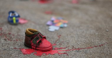 A child&#039;s shoe painted red lies on the floor, near the Embassy of Egypt, during a protest in solidarity with Palestinians against Israeli genocide, Santiago, Chile, Aug. 17, 2025. (Reuters Photo)
