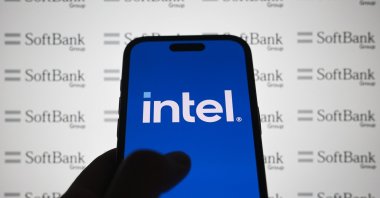 A logo of Intel is displayed on a smartphone with the logo of SoftBank Group in the background, Aug. 19, 2025. (AA Photo)